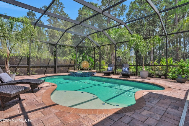 view of swimming pool featuring a patio, glass enclosure, and a pool with connected hot tub