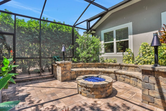 view of patio / terrace featuring glass enclosure and a fire pit