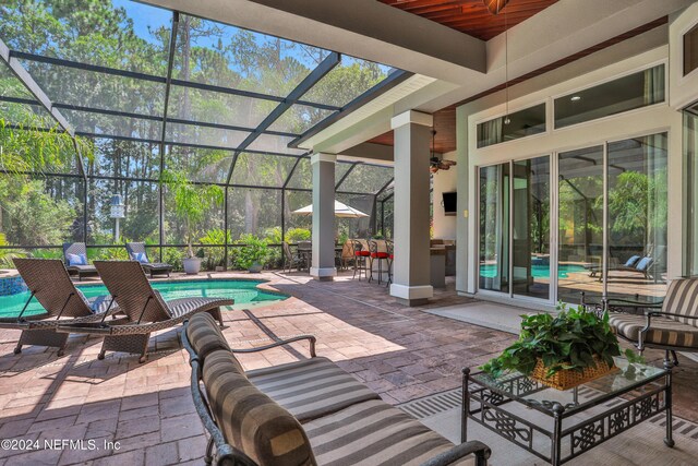 view of patio featuring ceiling fan, an outdoor pool, glass enclosure, and outdoor lounge area