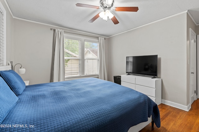 bedroom with wood-type flooring, ornamental molding, and ceiling fan