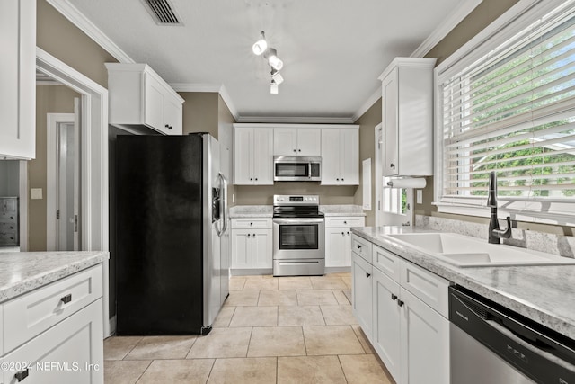 kitchen featuring crown molding, stainless steel appliances, track lighting, light tile floors, and sink