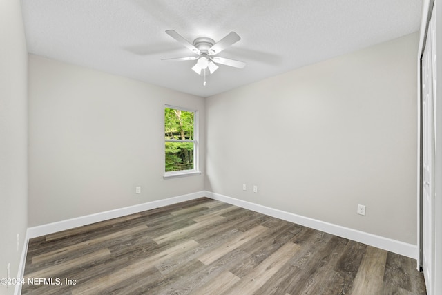 empty room featuring ceiling fan, a textured ceiling, and wood-type flooring