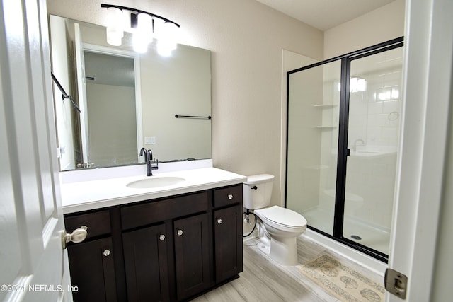 bathroom featuring hardwood / wood-style flooring, vanity, toilet, and walk in shower