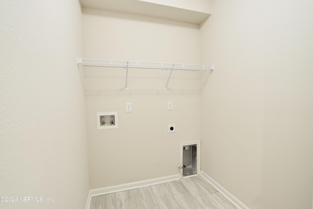 laundry area with hookup for an electric dryer, hookup for a washing machine, and light wood-type flooring