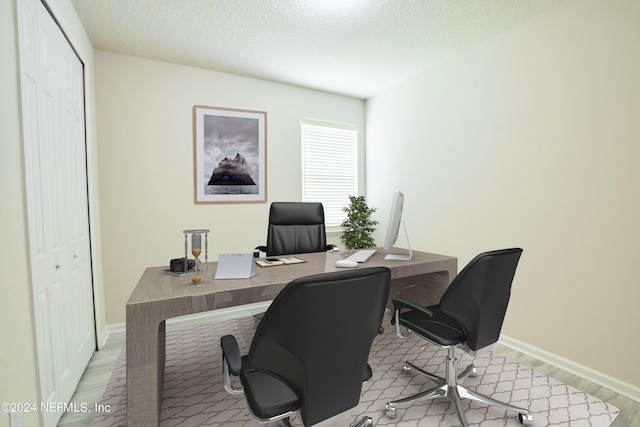 office space with a textured ceiling and light hardwood / wood-style floors