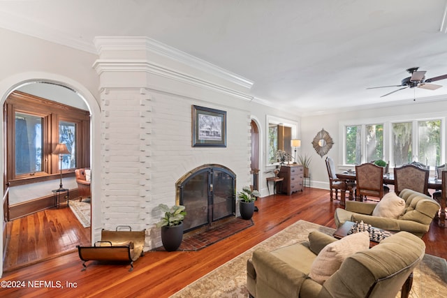 living room with a brick fireplace, ceiling fan, and hardwood / wood-style flooring