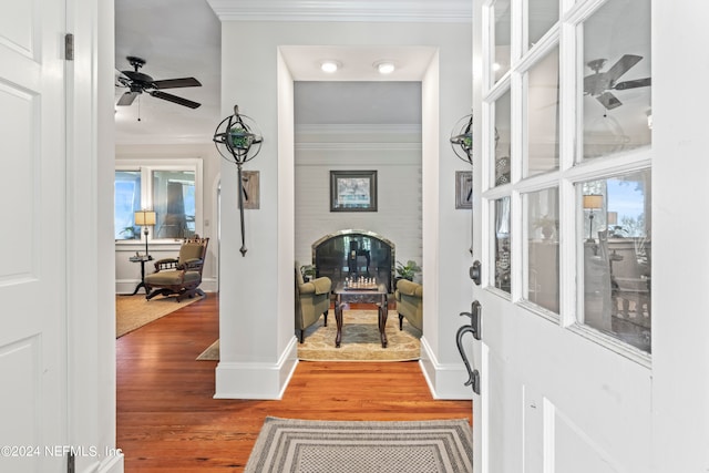 entrance foyer featuring ornamental molding, wood-type flooring, and ceiling fan