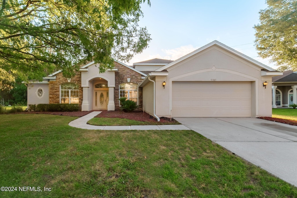 ranch-style house featuring a garage and a front yard