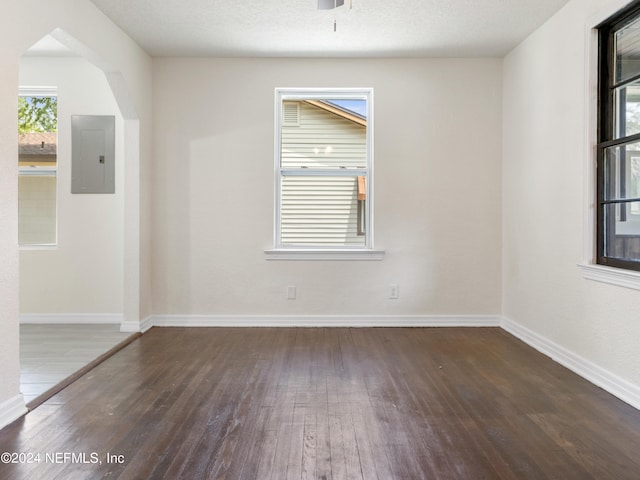 unfurnished room with hardwood / wood-style flooring and a textured ceiling