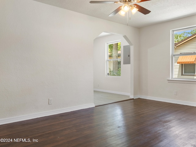 empty room featuring a textured ceiling, dark wood-type flooring, and ceiling fan