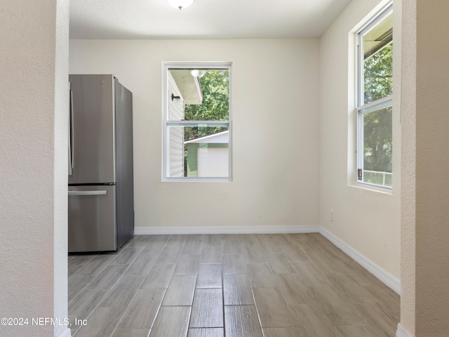 unfurnished dining area featuring light wood-type flooring