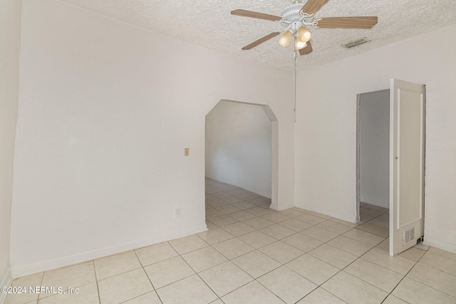 unfurnished room featuring a textured ceiling, ceiling fan, and light tile floors