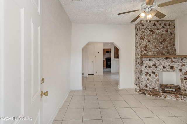 hall featuring light tile floors and a textured ceiling