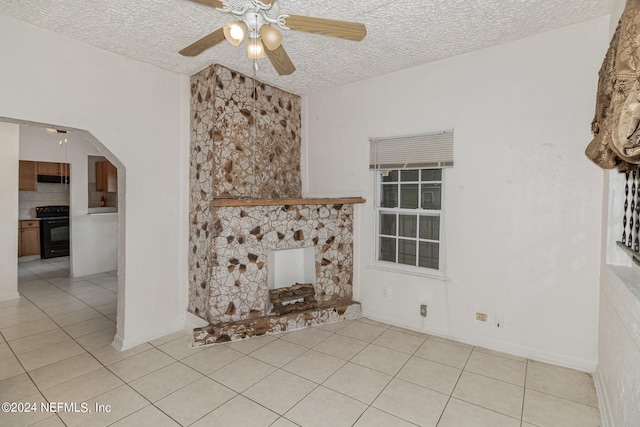 unfurnished living room featuring ceiling fan, a textured ceiling, and light tile flooring