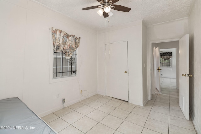 interior space with ceiling fan, a textured ceiling, and ornamental molding