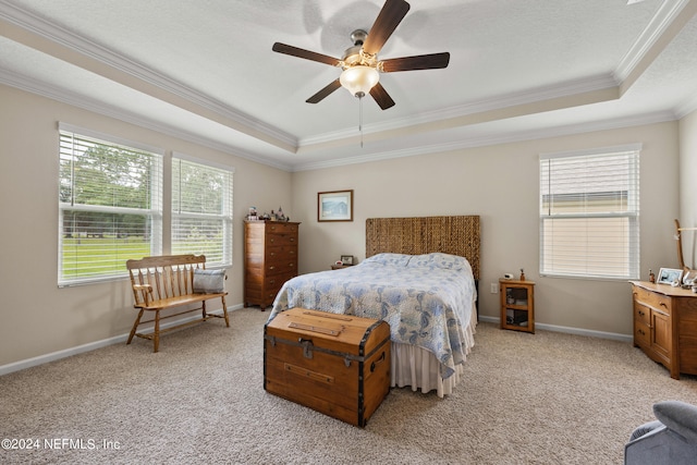 bedroom featuring ceiling fan, a raised ceiling, carpet, and ornamental molding