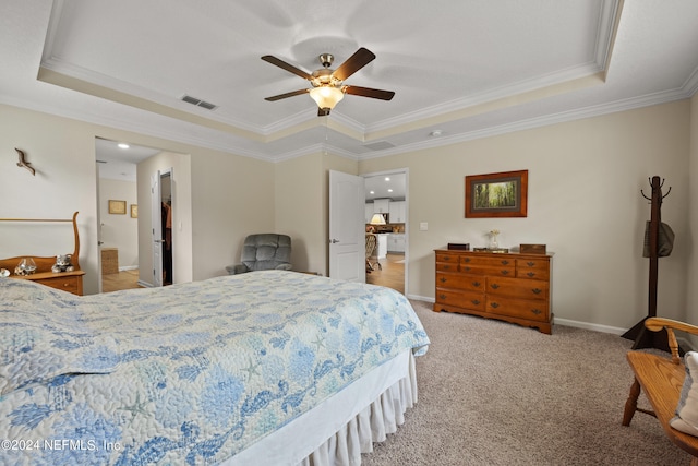 carpeted bedroom with ceiling fan, a raised ceiling, and ornamental molding