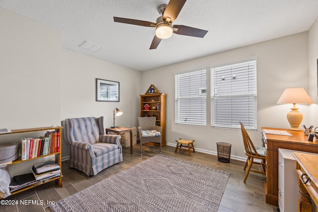 office area featuring ceiling fan, a textured ceiling, and dark wood-type flooring