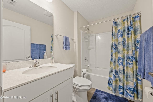 full bathroom with a textured ceiling, toilet, shower / tub combo with curtain, and oversized vanity