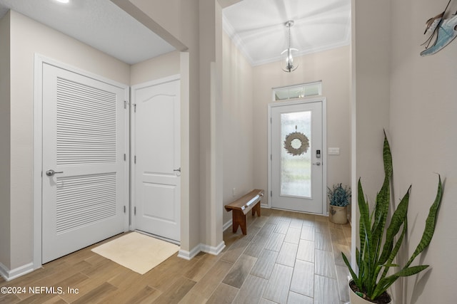 foyer featuring crown molding and light wood-type flooring