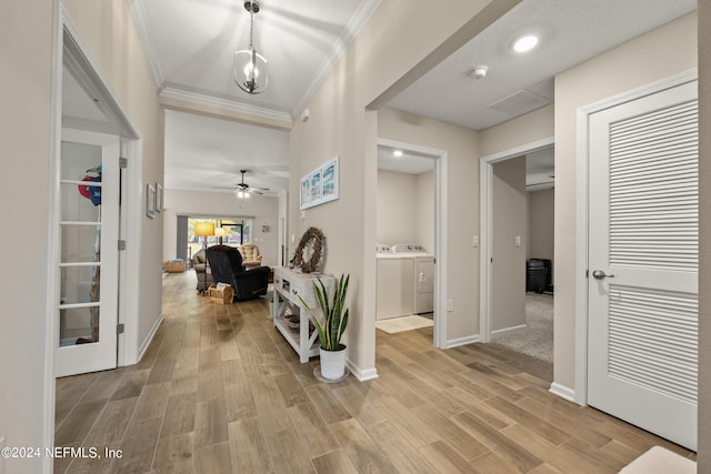 foyer entrance with ceiling fan, light hardwood / wood-style flooring, crown molding, and separate washer and dryer