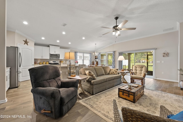 living room featuring light hardwood / wood-style floors, crown molding, and lofted ceiling