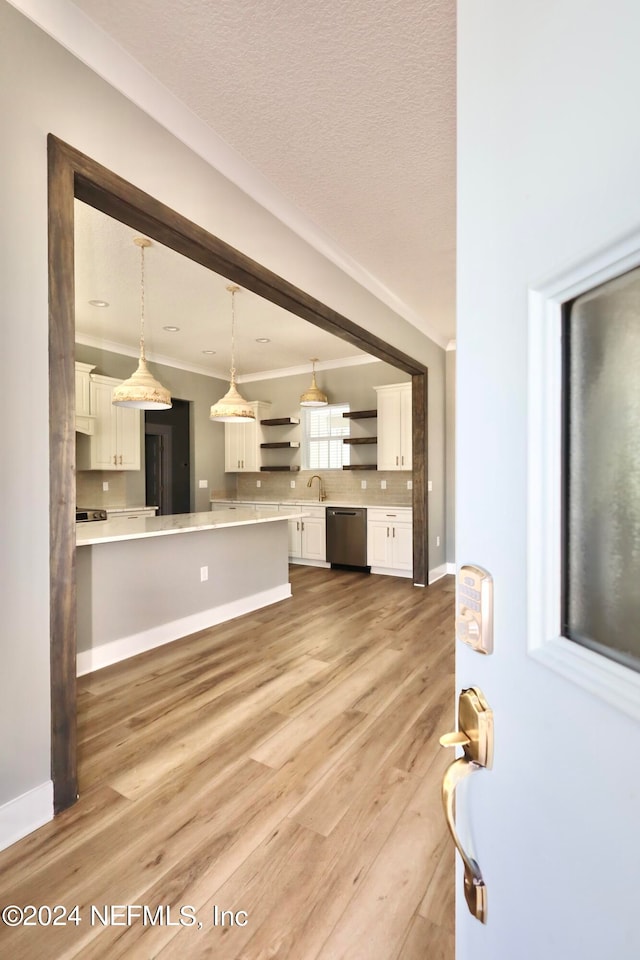 unfurnished living room with sink, light hardwood / wood-style flooring, and a textured ceiling