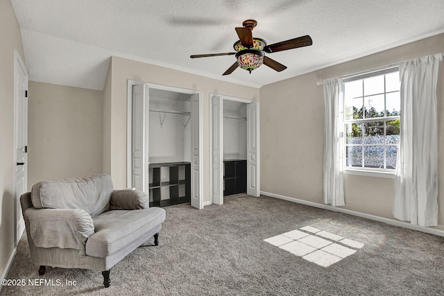 sitting room with ceiling fan, a textured ceiling, and light colored carpet