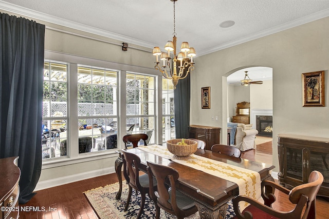 dining room featuring ceiling fan with notable chandelier, crown molding, dark hardwood / wood-style flooring, and a textured ceiling