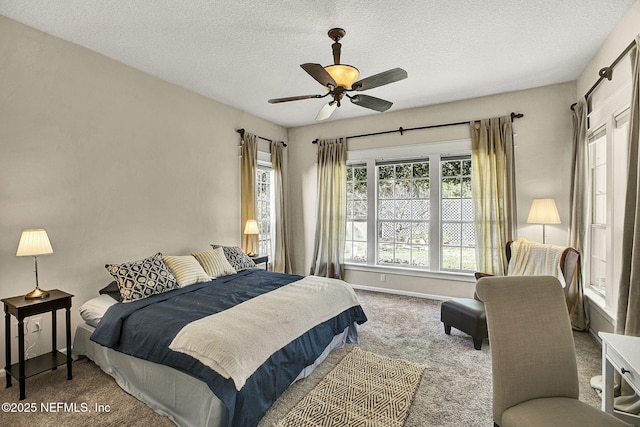 carpeted bedroom with ceiling fan and a textured ceiling