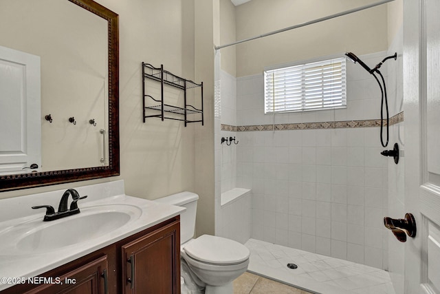 bathroom with vanity, a tile shower, and toilet