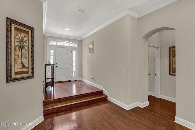 foyer entrance featuring a textured ceiling, hardwood / wood-style floors, and crown molding