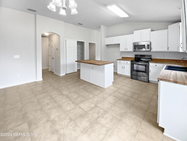 kitchen featuring appliances with stainless steel finishes, white cabinets, wooden counters, sink, and light tile floors