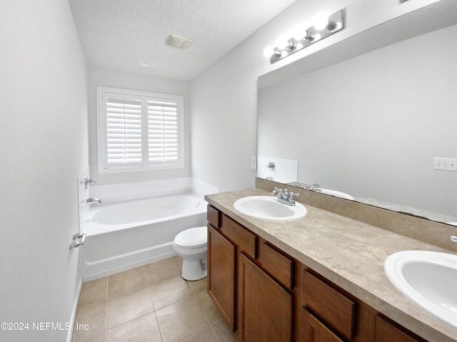 bathroom with a textured ceiling, tile floors, dual vanity, a bathing tub, and toilet