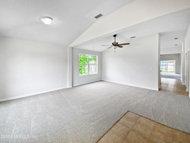 spare room with ceiling fan, lofted ceiling, and light carpet