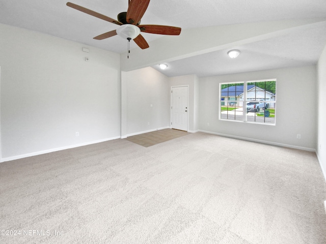 empty room with vaulted ceiling, carpet, and ceiling fan