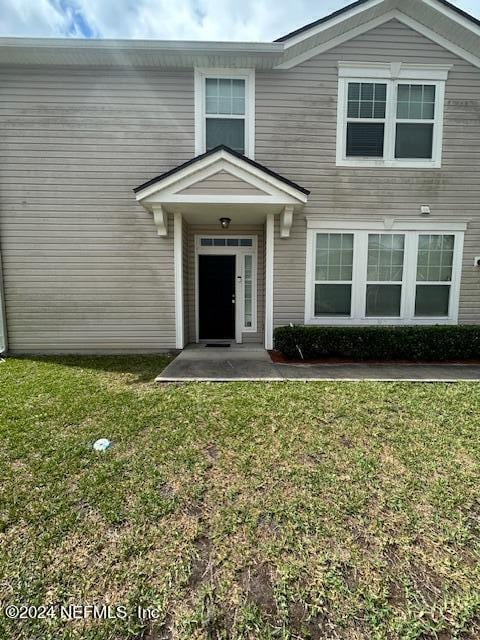 entrance to property with a lawn