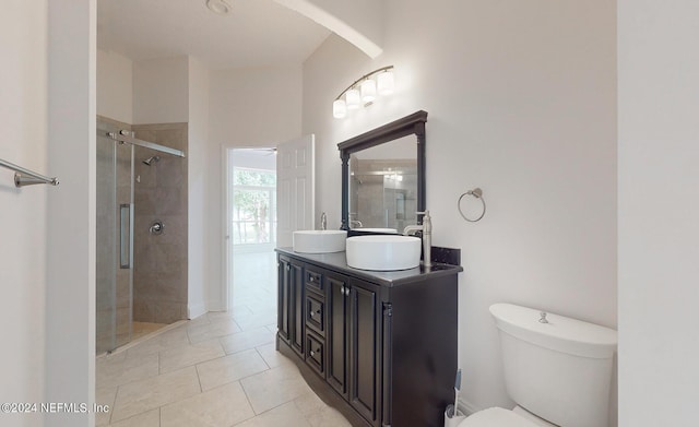 bathroom with tile patterned flooring, vanity, toilet, and a shower with shower door