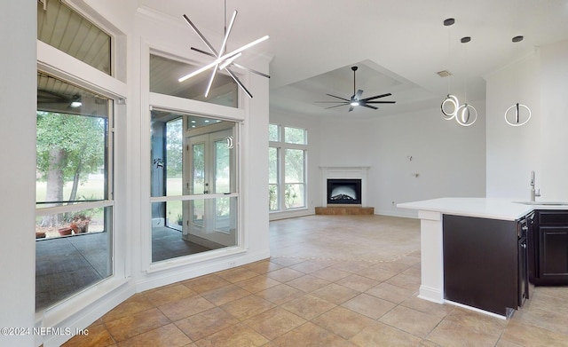 tiled living room featuring french doors, sink, a high ceiling, and ceiling fan with notable chandelier