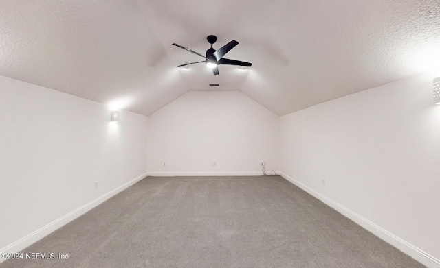 additional living space with a textured ceiling, ceiling fan, carpet floors, and lofted ceiling