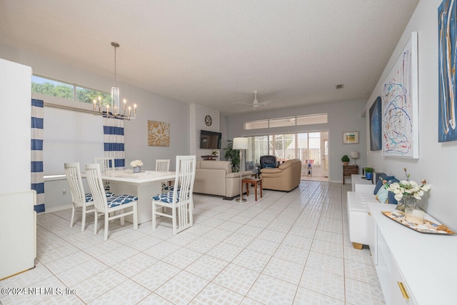 tiled dining space with ceiling fan with notable chandelier