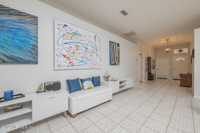 tiled living room with a notable chandelier