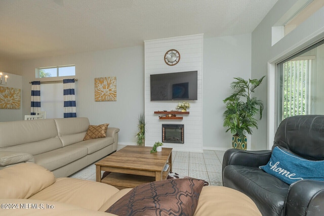 living room featuring a large fireplace, a wealth of natural light, and light tile patterned flooring