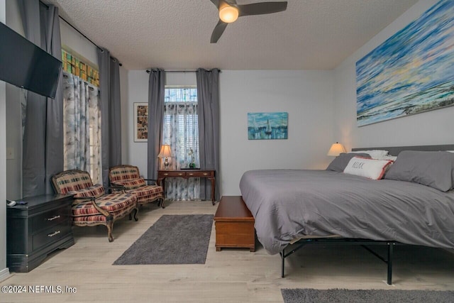 bedroom featuring a textured ceiling, light hardwood / wood-style floors, and ceiling fan