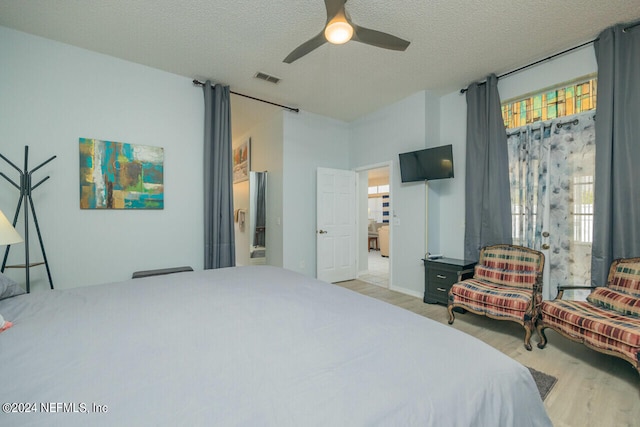 bedroom featuring ceiling fan, a textured ceiling, and multiple windows