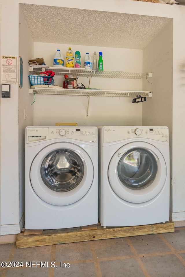 laundry room with a textured ceiling and washing machine and clothes dryer