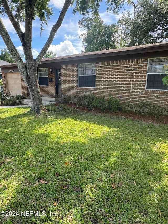 ranch-style house with a garage and a front lawn