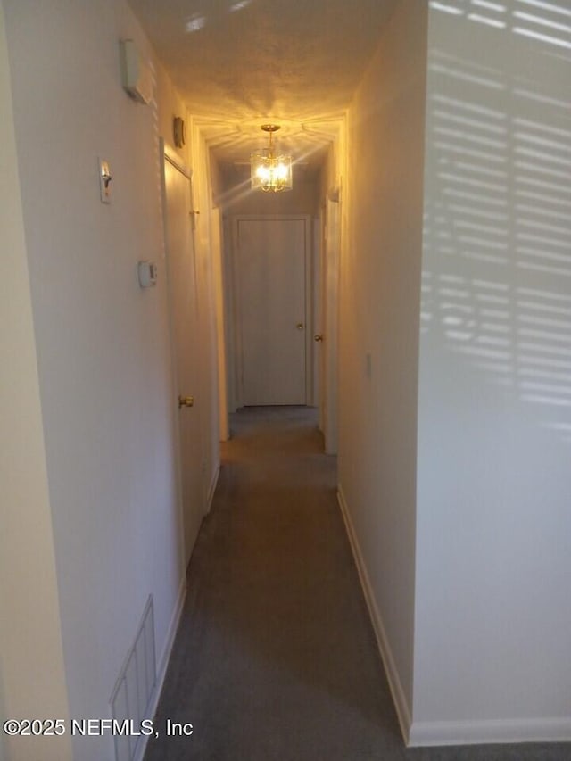 hallway featuring an inviting chandelier