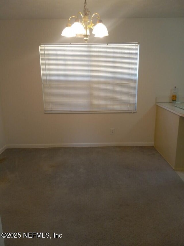 unfurnished dining area featuring carpet flooring and a notable chandelier