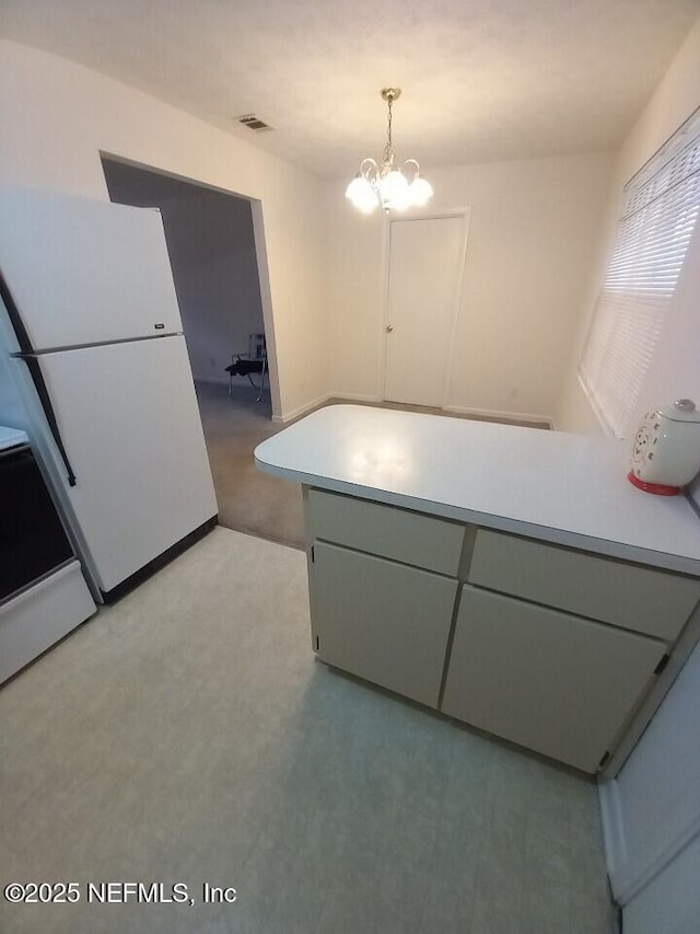 kitchen featuring pendant lighting, range, and an inviting chandelier